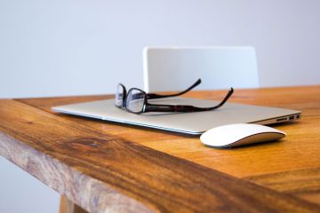Laptop, Brille, PC Maus auf einem Tisch